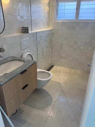 Modern bathroom with timber vanity, wall-hung toilet and glass shower