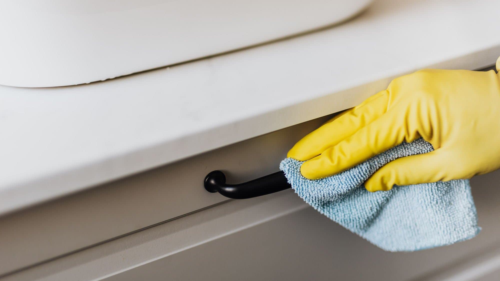 Gloved hand wiping cabinet hardware — illustrative of deep cleaning for Sydney homes